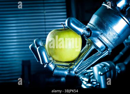 Main robot tenant la pomme fraîche Banque D'Images