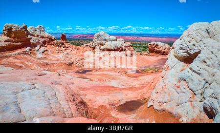 Vol aérien à travers des couches de grès tourbillonnantes et Red Rock affleure White Pocket Banque D'Images