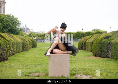 Danseuse de ballet posant en tutu noir sur piédestal dans le parc de la ville Banque D'Images