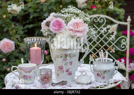 arrangement de table avec bouquet de rose, pivoines et gypsophila, porcelaine vintage et lanterne dans le jardin d'été Banque D'Images