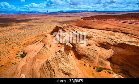 Formations aériennes de grès et plaines désertiques avec Mesas lointaines survolées Banque D'Images