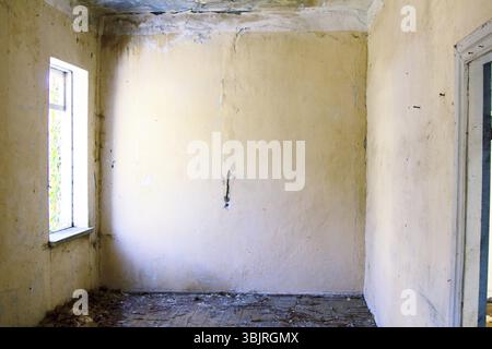 Maison abandonnée avec chambres vides, signes de la désolation Banque D'Images