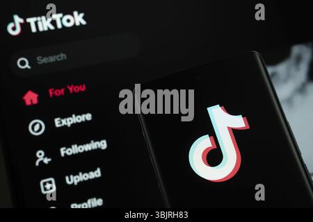 Dhaka, Bangladesh - 18 mars 2025 : le logo du tiktok est affiché sur l'écran d'un smartphone, et le site tiktok est visible sur l'écran d'un ordinateur Banque D'Images