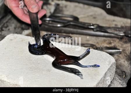 Verrerie à Murano, Venise, Vénétie, Italie, Europe, une figurine de chat en verre noir est moulée sur une pierre, Europe Banque D'Images