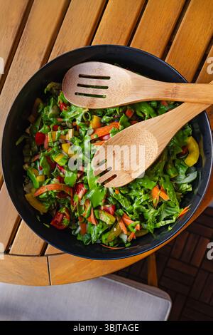 Salade de légumes frais avec vinaigrette de déesse verte servie dans un bol sur une table en bois, vue de dessus Banque D'Images