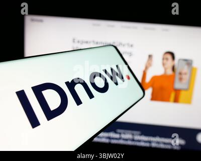 Stuttgart, Allemagne - 2025 : smartphone avec le logo de la société de vérification d'identité IDnow GmbH sur l'écran en face du site Web. Banque D'Images