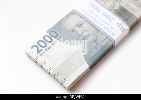Pekanbaru, Indonésie - 21 mars 2025 : une pile de billets de banque rupiah indonésiens RP 2,000 isolés sur fond blanc pour THR sur Eid al-Fitr ou Lebaran Banque D'Images