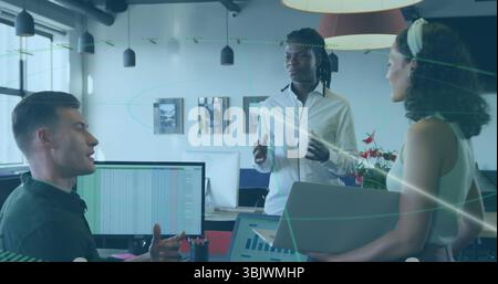 Présentation homme debout en chemise blanche expliquant la feuille de calcul sur le moniteur au bureau, avec ordinateur portable Banque D'Images