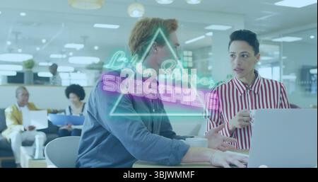 Collègues portant un chemisier et une chemise collaborant sur un ordinateur portable dans un bureau ouvert, avec superposition de néon Banque D'Images