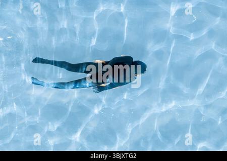 Londres, Royaume-Uni. 17 juin 2025. Météo britannique – Une femme profite des conditions chaudes pour nager dans la piscine extérieure surélevée Sky Pool à Embassy Gardens à Nine Elms. On prévoit que les températures dans la capitale dépasseront les 30 °C d'ici le week-end. Credit : Stephen Chung / Alamy Live News Banque D'Images