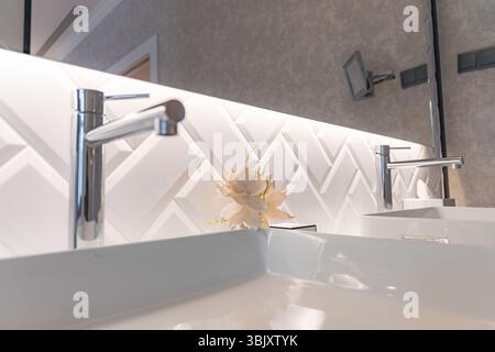 Salle de bains moderne avec carreaux à chevrons et accessoires chromés Banque D'Images