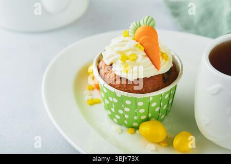 Gâteau aux carottes cupcakes pour Pâques. Cupcakes aux carottes avec glaçage au fromage à la crème décoré de minuscules carottes de massepain sur dos blanc Banque D'Images