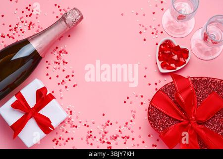 Bouteille de champagne, verres et boîte cadeau en forme de coeur avec un ruban rouge sur fond rose. Postcar concept de la Saint-Valentin Banque D'Images