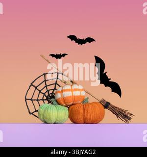 Citrouilles orange vert tricoté, toile d'araignée noire tricotée, chauves-souris et balai de sorcière sur fond dégradé, vue de face. Concept d'Halloween. Jouets tricotés faits à la main pour enfants et décoration de maison de vacances. Banque D'Images