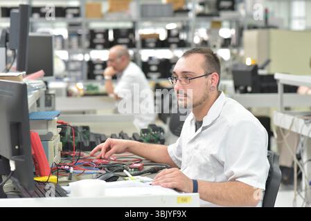 En micro-électronique de l'ingénierie : les travailleurs dans la production et l'assemblage de composants électroniques de haute technologie dans une usine moderne Banque D'Images