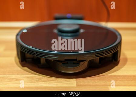 Le robot-aspirateur est chargé à la base. Banque D'Images