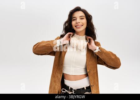 Une jeune femme montre son sens de la mode avec une veste élégante, souriante. Banque D'Images