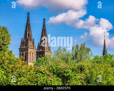 Majestueuse cathédrale gothique. Twin Spires Against a Bright Sky. Un magnifique mélange d'histoire et de nature, parfait pour capturer l'essence de la grandeur architecturale et du patrimoine culturel. Stock photo Banque D'Images