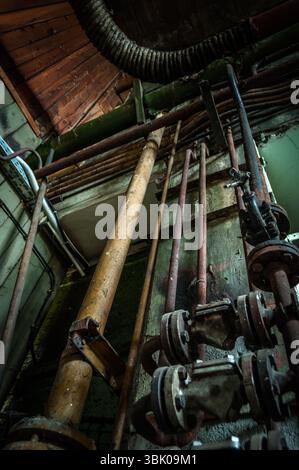Les vieux tuyaux rouillés ont été inclinés dans les bâtiments industriels Banque D'Images