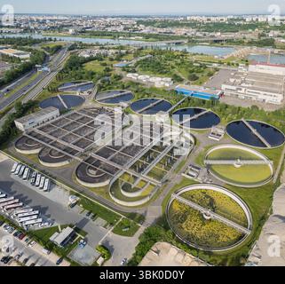 Vue aérienne écologique de la station d'épuration des eaux usées près de Lyon, France, avec un horizon urbain – gestion durable de l'eau et protection de l'environnement Banque D'Images