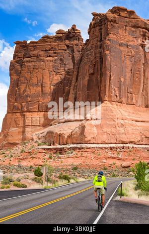 Moab, Utah, États-Unis - 25 mai 2025 : cycliste sur une route à travers des paysages spectaculaires dans le parc national des Arches à Moab Banque D'Images