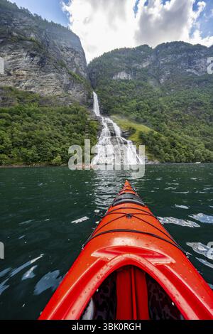 Excursion en kayak sur le Geirangerfjord à la cascade Freier, pointe d'un kayak rouge dans le fjord, paysage atmosphérique du fjord, vue à la première personne, près de Geiran Banque D'Images