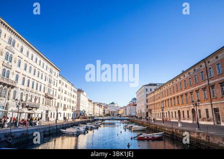 TRIESTE, ITALIE - 17 DÉCEMBRE 2024 : Trieste canal Grande et l'église de Sant Antonio Taumaturgo avec des bateaux, pastel palazzi sur le front de mer. Canal Banque D'Images