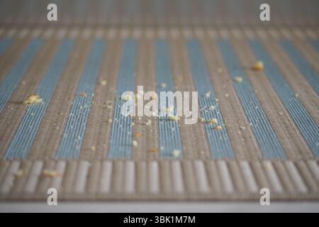 Miettes dispersées sur un tapis bleu et gris Banque D'Images