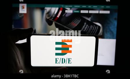 Stuttgart, Allemagne - 24-04-2025 : personne tenant un téléphone portable avec le logo de Einkaufsbuero Deutscher Eisenhaendler (EDE) sur l'écran devant la page web. Banque D'Images