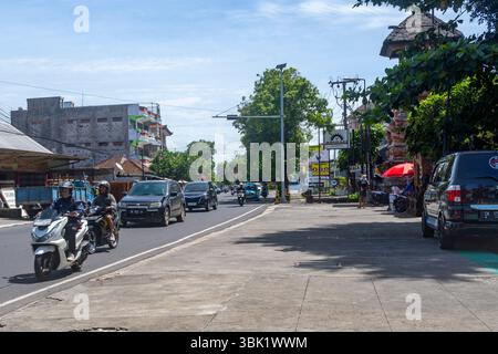 Bali, Indonésie - 19 décembre 2024 : voie publique avec de nombreuses voitures et motos de passage Banque D'Images