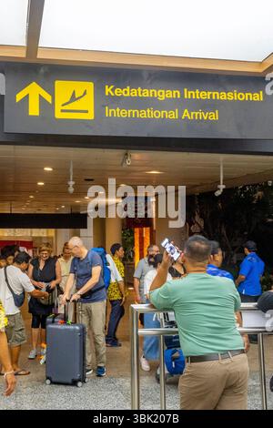 Bali, Indonésie - 19 décembre 2024 : avion de l'aéroport de Bali la nuit avec de nombreux touristes à la section des arrivées Banque D'Images