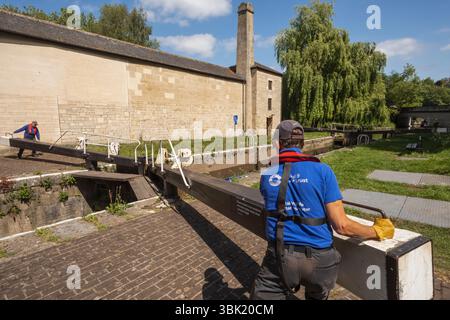 Angleterre, Somerset, Bath, le canal Kennet et Avon, Widcombe Lock et Thimble Mill Lock, Men Opening Lock Gates Banque D'Images