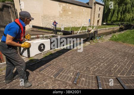 Angleterre, Somerset, Bath, le canal Kennet et Avon, Widcombe Lock et Thimble Mill Lock, Men Opening Lock Gates Banque D'Images