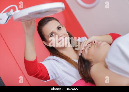 dermatologue effectuant l'épilation au laser sur le visage du patient Banque D'Images
