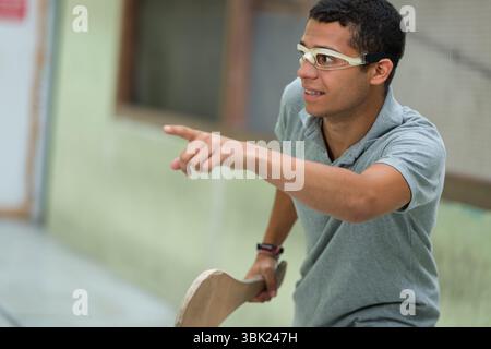 jeune homme jouant à la pelote portant une protection oculaire Banque D'Images