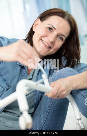 une femme positive visse un meuble Banque D'Images