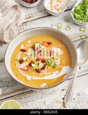 Soupe crémeuse de lentilles à la citronnelle, au lait de coco et au piment rouge, servie dans un bol – chaude, épicée et à base de plantes, parfaite pour le déjeuner ou un dîner léger. Banque D'Images