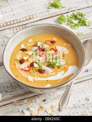 Soupe crémeuse de lentilles à la citronnelle, au lait de coco et au piment rouge, servie dans un bol – chaude, épicée et à base de plantes, parfaite pour le déjeuner ou un dîner léger. Banque D'Images