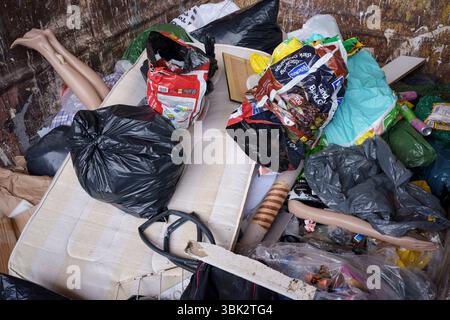 Les jambes et un bras d'un mannequin de vente au détail dépassent d'autres déchets de décharge dans une benne au centre de déchets ménagers et de recyclage de l'arrondissement de Wandsworth sur Smugglers Way, le 17 juin 2025, à Londres, en Angleterre. Les déchets mis en décharge sont l'élimination de déchets qui ne peuvent pas être réutilisés, recyclés ou valorisés, dans ou sur le sol. Banque D'Images