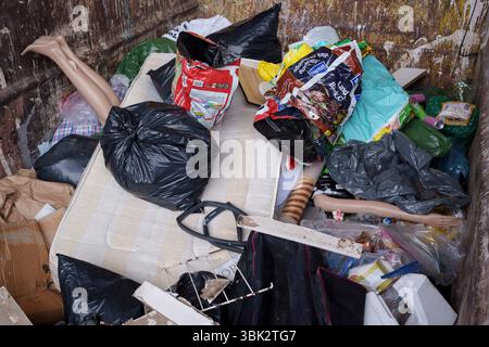 Les jambes et un bras d'un mannequin de vente au détail dépassent d'autres déchets de décharge dans une benne au centre de déchets ménagers et de recyclage de l'arrondissement de Wandsworth sur Smugglers Way, le 17 juin 2025, à Londres, en Angleterre. Les déchets mis en décharge sont l'élimination de déchets qui ne peuvent pas être réutilisés, recyclés ou valorisés, dans ou sur le sol. Banque D'Images
