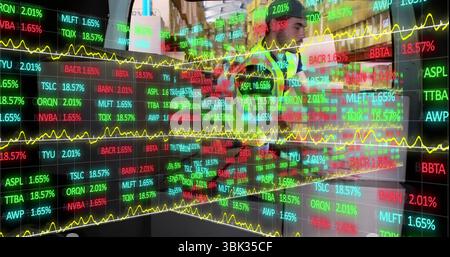 Analystes collaborateurs portant des costumes étudiant des tickers avec des graphiques sur l'écran LED sur le plancher des marchés Banque D'Images