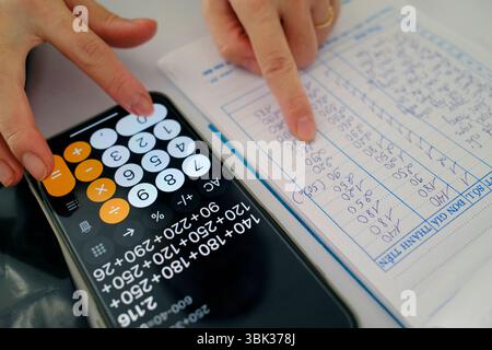 Femme utilisant une calculatrice dans un magasin. Comptabilité. Gros plan sur les mains. Kontum. Vietnam. Banque D'Images