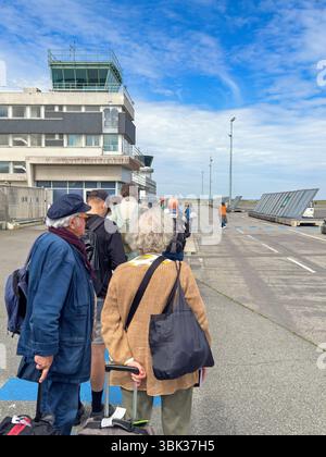 Passagers faisant la queue pour monter à bord d'un avion sur la piste Banque D'Images