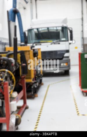 La cabine blanche de semi-camion est montrée dans un garage de conception plate avec des machines jaunes et des tuyaux bleus Banque D'Images