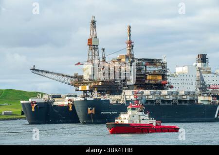 L'énorme navire pionnier Spirit arrive à Dales Voe dans les Shetland, livrant la plate-forme Ninian Northern au sommet pour le déclassement, marquant un m Banque D'Images