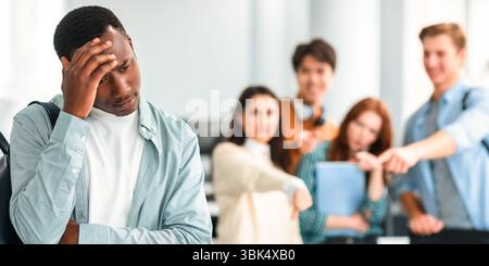 Les gens se moquer et se moquer d'un triste homme noir Banque D'Images