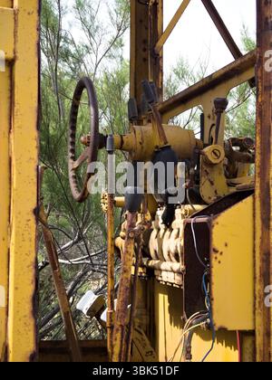 Commandes de machine jaunes rouillées, d'un tracteur abandonné pourri dans un champ Banque D'Images