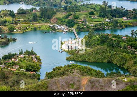 Superbe vue aérienne de Guatape, mettant en valeur les eaux turquoises, les collines verdoyantes et les communautés animées autour de la pierre de Peñol. Parfait pour le tourisme en Colombie. Banque D'Images