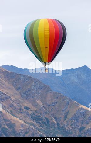 Une montgolfière survolant les crêtes montagneuses près de Queenstown, Otago, Nouvelle-Zélande Banque D'Images
