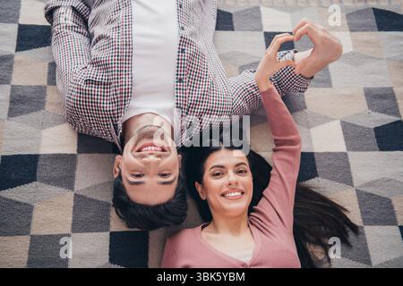 Jeune couple souriant et profitant de moments doux ensemble à la maison montrant l'amour et la connexion dans un salon confortable et lumineux Banque D'Images